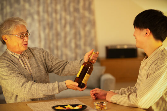 息子からウイスキーのプレゼントをされる父親