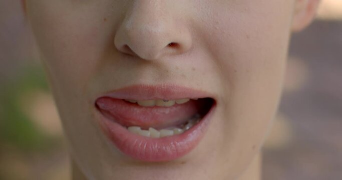 Close-up smile young woman mouth, lips, teeth close up. Lifestyle playing to attract attention. Flirting as tool for attracting positive attention. Nonverbal Communication as desire for interaction.