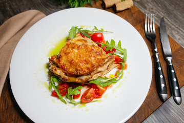 Lasagna with spicy chorizo sausage, wild mushrooms in cream sauce, garnished with arugula salad and cherry tomatoes