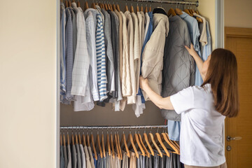 Elegant woman, she is decluttering her wardrobe and choosing clothes