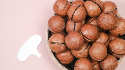 a dish with macadamia nuts. view from above. Organic macadamia nut on a pink background - a close-up of a natural macadamia nut on a light background is a copy space for business. Useful product