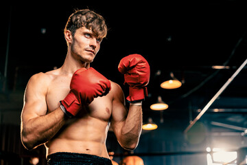 Boxing fighter shirtless posing, caucasian man boxer wearing red glove in defensive guard stance...