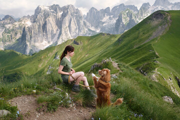 girl and Tolling retriever dog in the mountains. Traveling with a pet, adventure animal. Hiking in the peaks of Montenegro, Albania