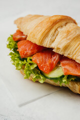 Rich croissant with salmon and herbs is an excellent breakfast with coffee