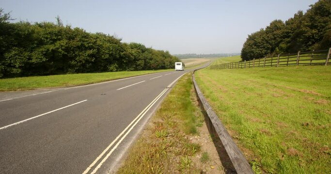 Wide shot looking down Carsington water dam with the dam road and traffic