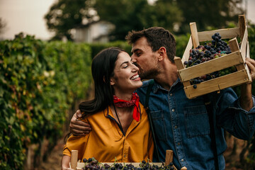 A moment of shared joy between a smiling Latin couple, immersed in the vineyard they nurture.