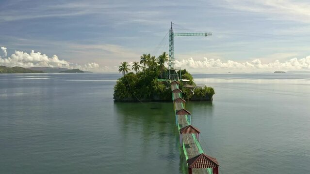 Fly past drone shot of Bacuag Hanging Bridge and Octopus Islet. Adventure Zipline attraction located in Bacuag, Surigao Del Norte. Philippines.