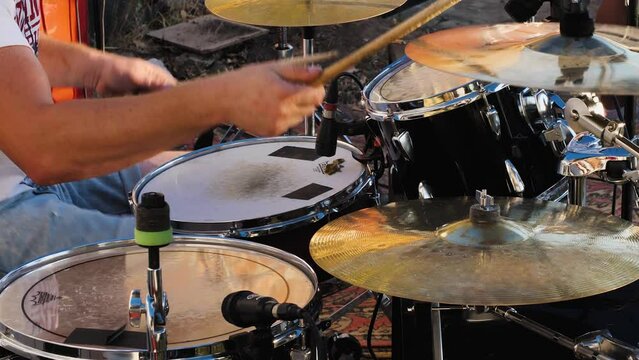 Professional drum kit close-up. Drummer with drums, live music concert. Musician's hands with sticks close-up. Fast playing on drums