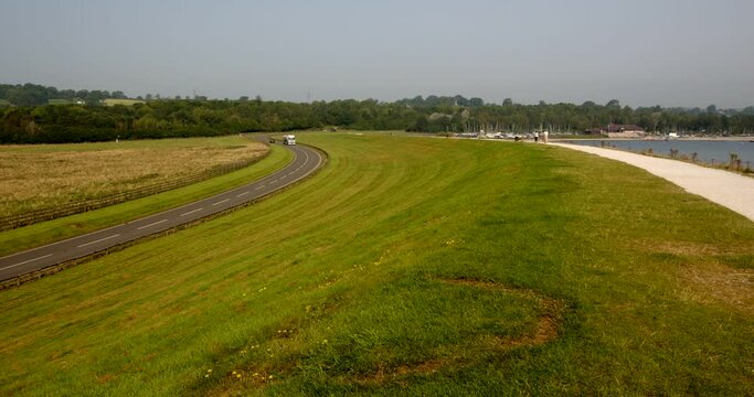 Looking up Carsington water dam, with the dam road to the left frame with traffic