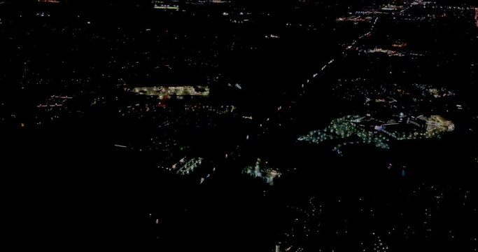 A 4K night  low shot before landing  from a plane on approach to Washington International  Dulles Airport  USA located in Virginia showing flood lighted buildings 26 miles from Washington DC