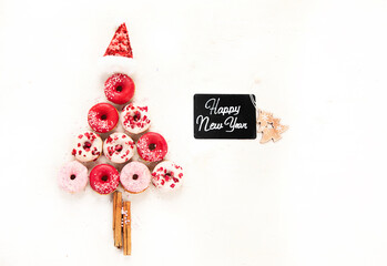 Christmas tree made of sweet donuts. Top view, flat lay on light background