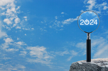 2024 start up flat icon with magnifying glass on rock mountain over blue sky with white clouds,...