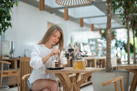 Girl in cafe eat cake with tea