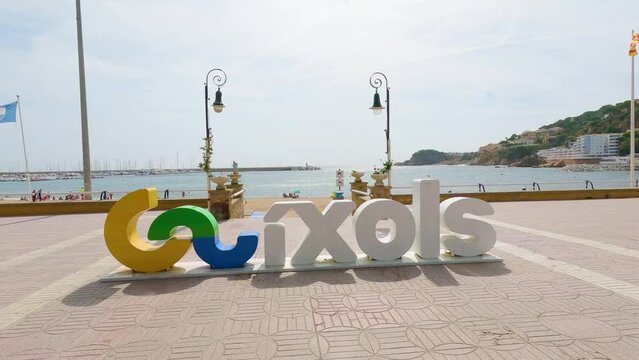 Sant Feliu de Gu&iacute;xols on the Costa Brava of Gerona Spain tourist town sign closeup with beach background