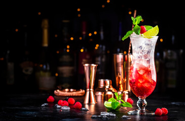 Raspberry lemonade non alcoholic cocktail or mocktail drink with raspberries, syrup, soda, lime,...