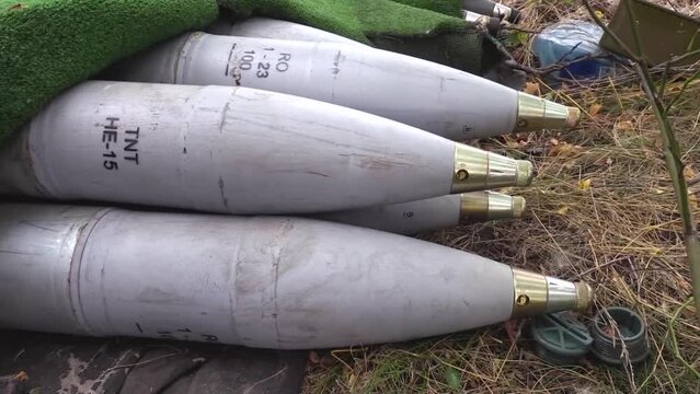 A lot of tank shells on the grass on the battlefield. Ammunition for heavy weapons. Russian-Ukrainian War 2022-2023