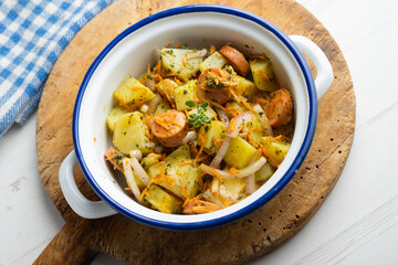 Sausage salad with potatoes, onion and green pesto.