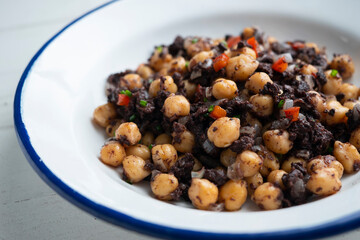 Stewed chickpeas with black pudding and red pepper. Traditional tapas from Barcelona.