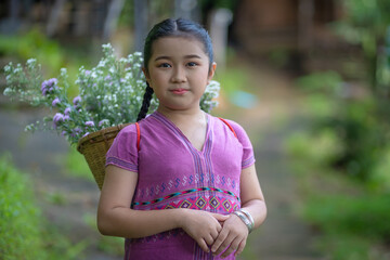 Portrait fashion teenagers wearing Karen dresses are happy in green natural at the local country village on the mountain of Chiang Mai, Northern Thailand.