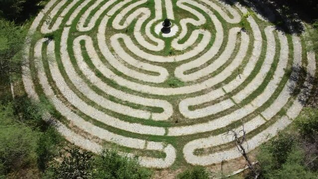 Aerial rising shot of a maze walkway with a stone pathway exhibit