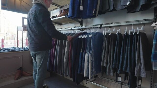 Scottish retail industry. Man shopping in store for tartan clothes to wear