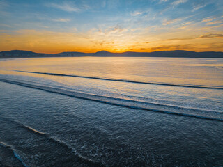 Pretty sunrise at the seaside with high cloud and low tide