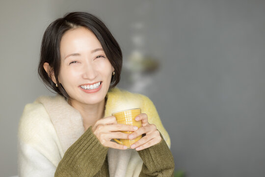 Asian (Japanese) woman drinking hot coffee, fall/winter.