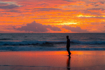 silhouette man walk on beach,phoenix sky Twilight with gloomy clouds