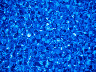 Water surface in a swimming pool with blue mosaic. Abstract background for swimming, summer sport, recreation, tourism.