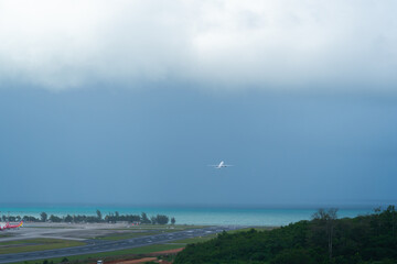 Obraz na płótnie Canvas White airplane off from runway ,airport near sea and big cloud
