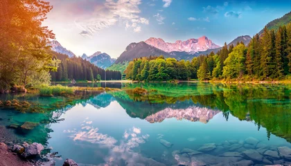  Calm morning view of Fusine lake. Colorful summer sunrise in Julian Alps with Mangart peak on background, Province of Udine, Italy, Europe. Beauty of nature concept background © Tatiana
