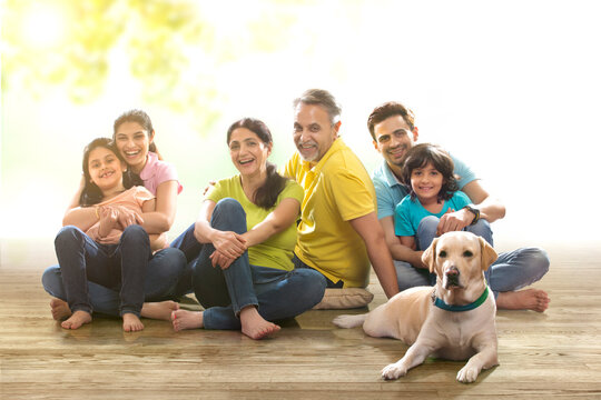 Portrait of multi-generation family with dog sitting on wooden floor
