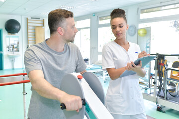 nurse assisting mature man to walk using walker