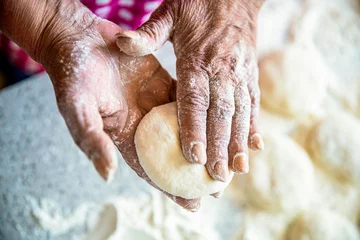 Selbstklebende Fototapeten Cooks dough for baking, pieces of raw dough. Homemade cakes dough in the women's hands. Process of making pies, hand. Hands pie dough. Womans hands rolling doughs for pies. Baking at home © Yevhen