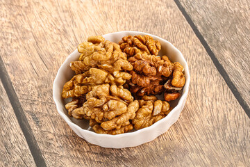 Cracked unshelled walnut in the bowl