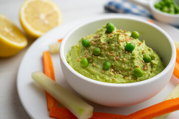 Green pea hummus served with carrot and cucumber.