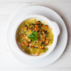 Mussels gratin. Gratin seafood dish with bread and parsley.