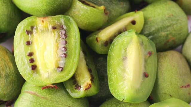Mini kiwi halves (Actinidia arguta), rotation in circle. sliced baby fruit, Turning. Selective focus. seasonal fruits.
