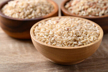 Thai brown rice seed in wooden bowl, Organic rice, Healthy food ingredient