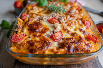 Tuna casserole with macaroni noodles, tomato cream sauce and mozzarella cheese in baking dish