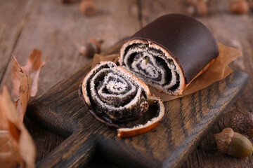 Bread with poppy seeds on a serving board on a wooden surface