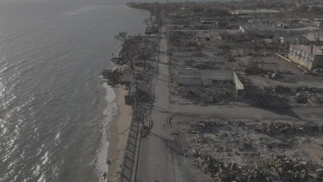 Aerial View of destroyed Downtown Lahaina after the Maui fire disaster. Burned maui homes and deserted streets. Apocalyptic views of Front Street amidst beautiful island sunshine.