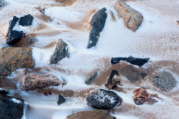Rocks And Sand Covered With Snow