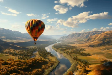 Foto auf Leinwand Red orange hot air balloon flies against a partly cloudy sky above a river through a beautiful valley with a backdrop of mountains © Tjeerd