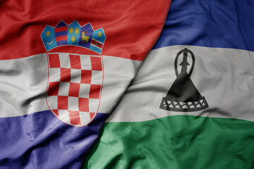 big waving national colorful flag of croatia and national flag of lesotho .