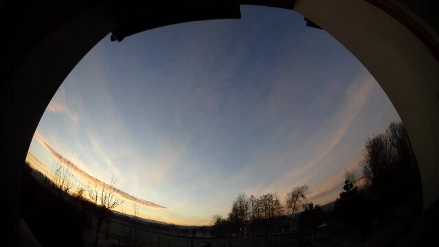 Window view - one day from night to evening with sky, colorful sunrise, moving clouds, halo Circumzenithal arc, Upper tangent arc, Plural parhelia horizon with cars traffic - timelapse, panorama 204.