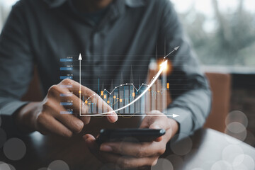 Business man using mobile phone app to trade stocks and forex. Financial chart analysis and economic growth concept is shown on screen.