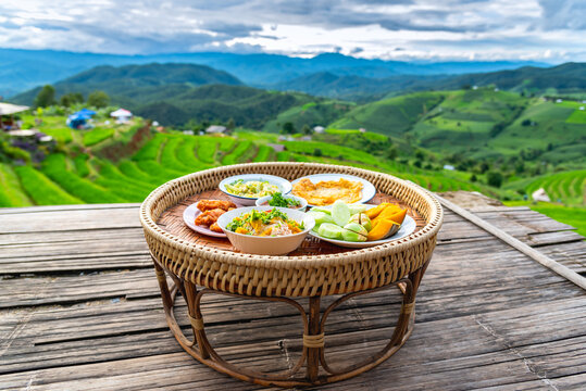 Asian food set in wooden pedestal, Khantoke, wooden utensil used as a small dining food table in northern Thailand and Laos.