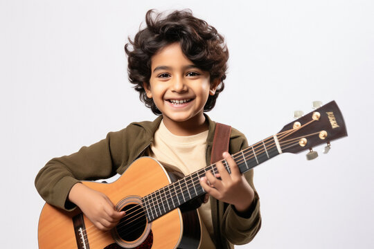 Cute little boy playing guitar on white background.