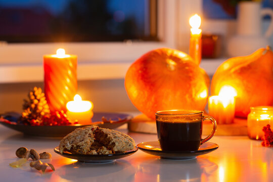 autumn still life with pumpkins, burning candles and cup of tea